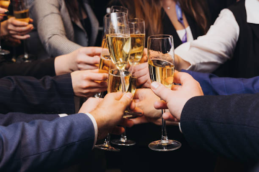 Colleagues in business attire raising a toast with sparkling wine glasses at a corporate event.